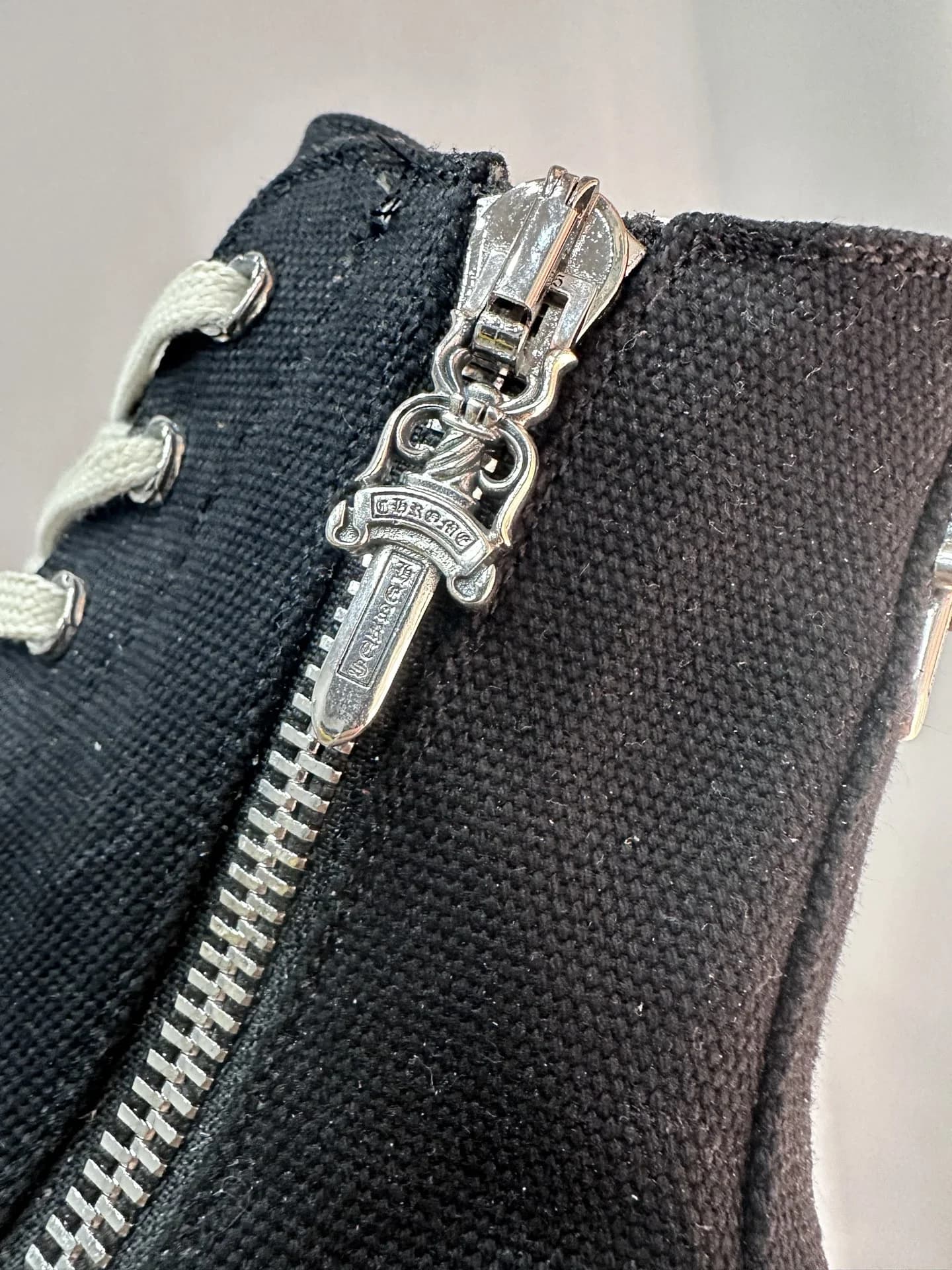 Крупный план серебряного пуллера-кинжала Chrome Hearts на молнии кед Rick Owens DRKSHDW