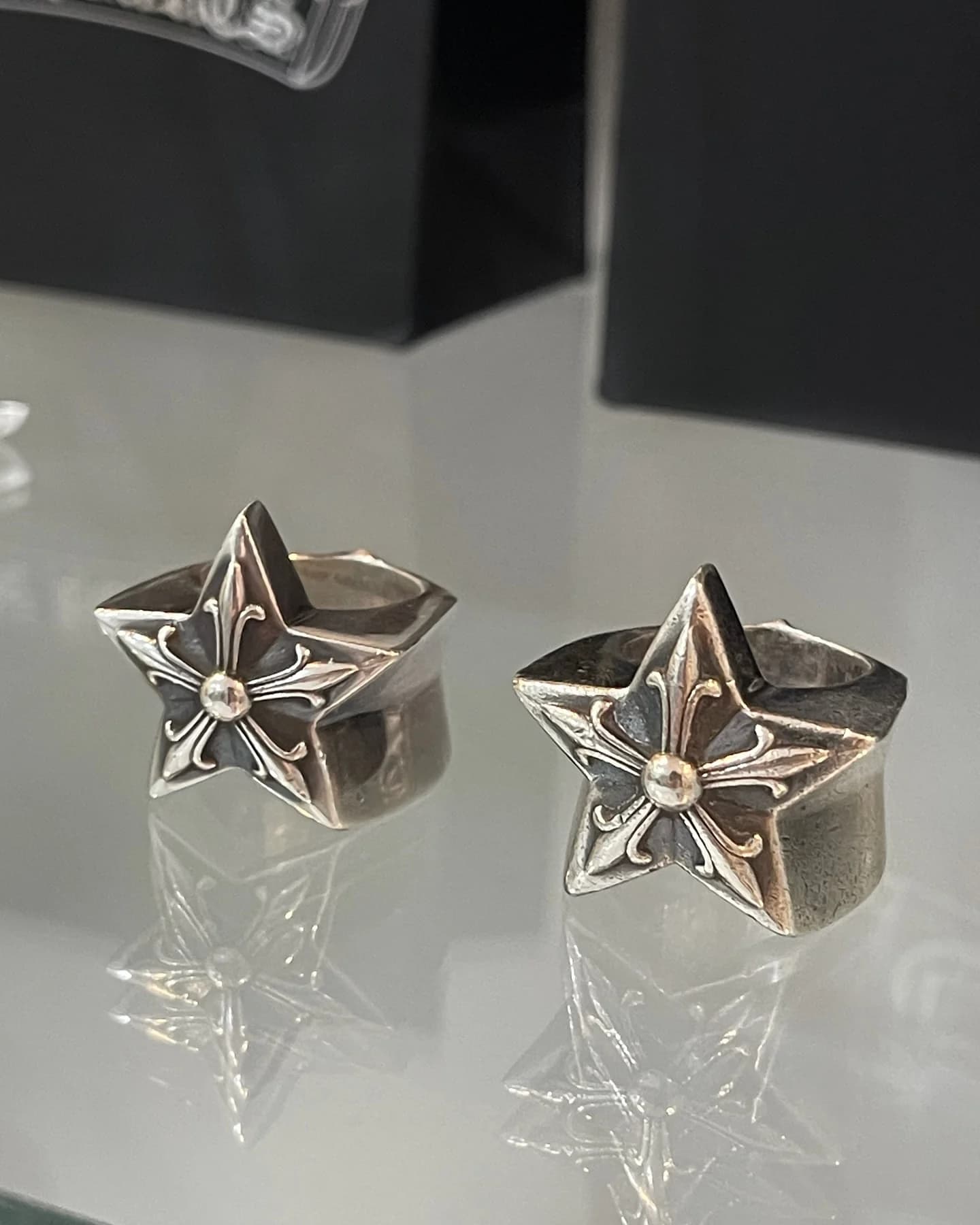 Два серебряных кольца Chrome Hearts Five Point Star на зеркальной поверхности