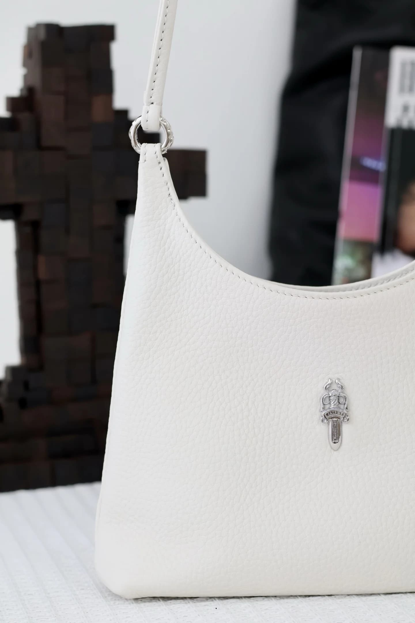 Вид сбоку и крепление плечевого ремня белой сумки Chrome Hearts