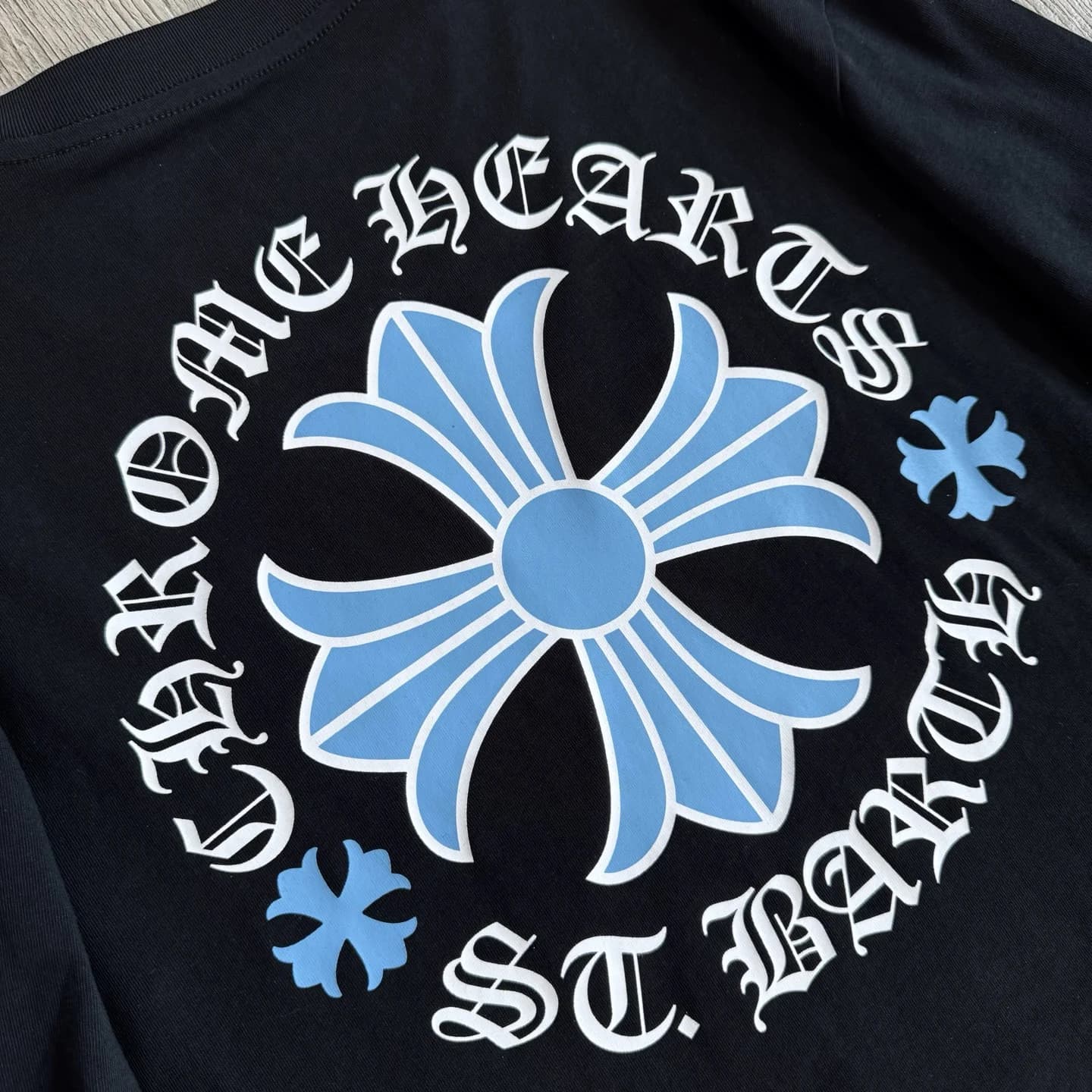 Крупный план голубого принта с крестом и надписью Chrome Hearts St. Barth на спине