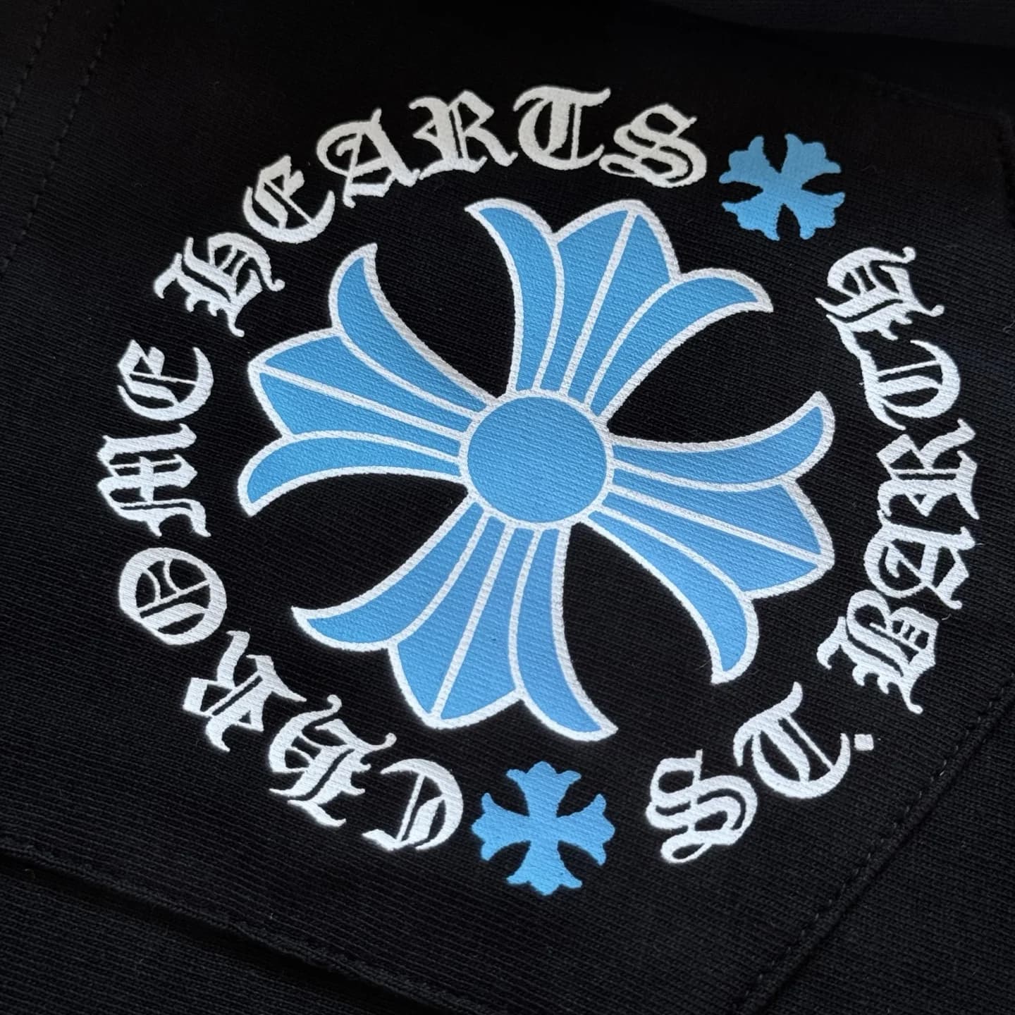 Деталь голубого принта-креста на черном лонгсливе Chrome Hearts