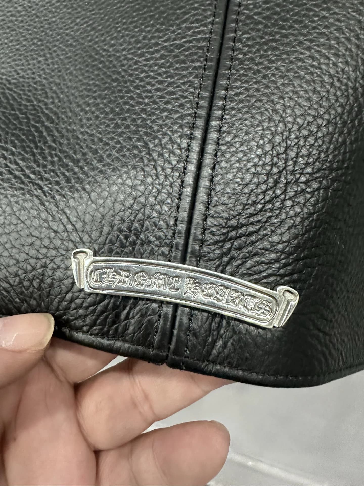 Деталь молнии на рукаве кожаной куртки Chrome Hearts с серебряным пуллером-кинжалом