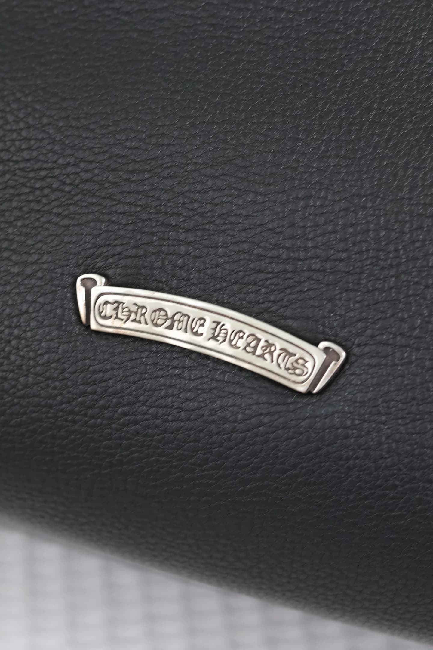 Крупный план серебряной пластины с логотипом Chrome Hearts