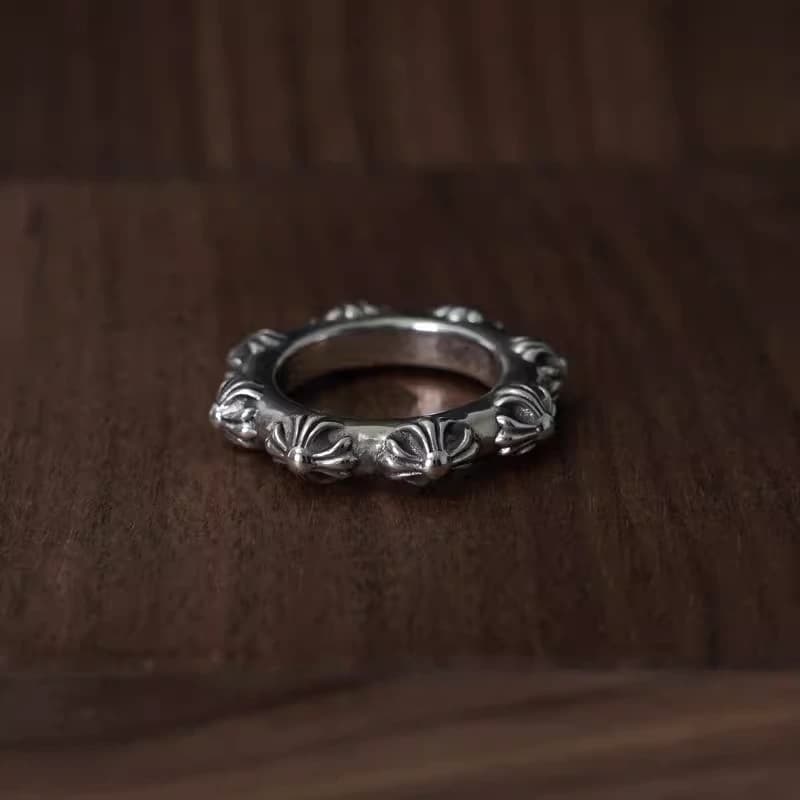 Серебряное кольцо с объемным крестовым узором на деревянной подставке