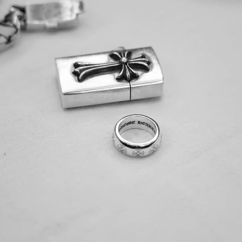 Серебряное кольцо с крестами рядом с фирменной коробкой с крестом