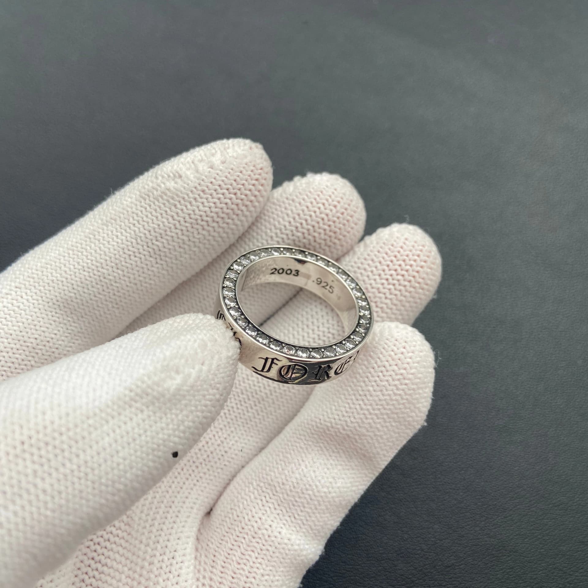 Серебряное кольцо Forever с муассанитами по контуру, ракурс в руке сбоку
