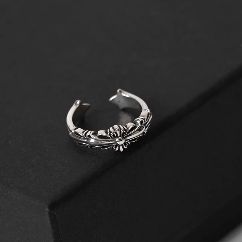 Серебряное кольцо с цветочным узором на тёмной коробке
