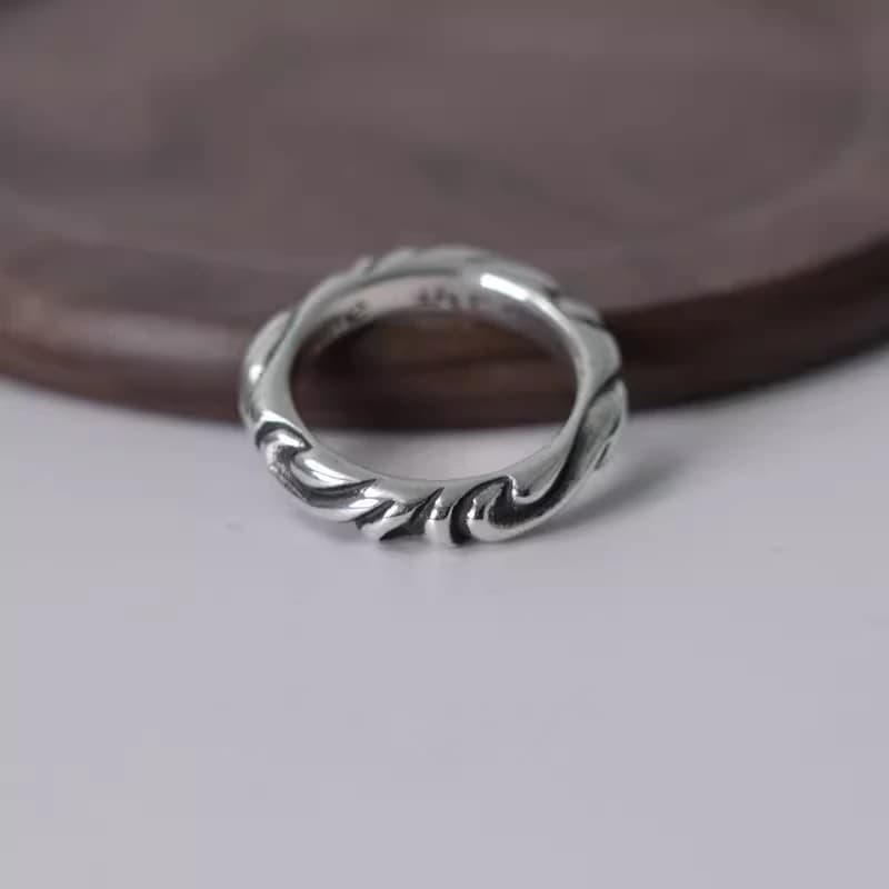 Серебряное кольцо с чернёным узором на деревянной подставке