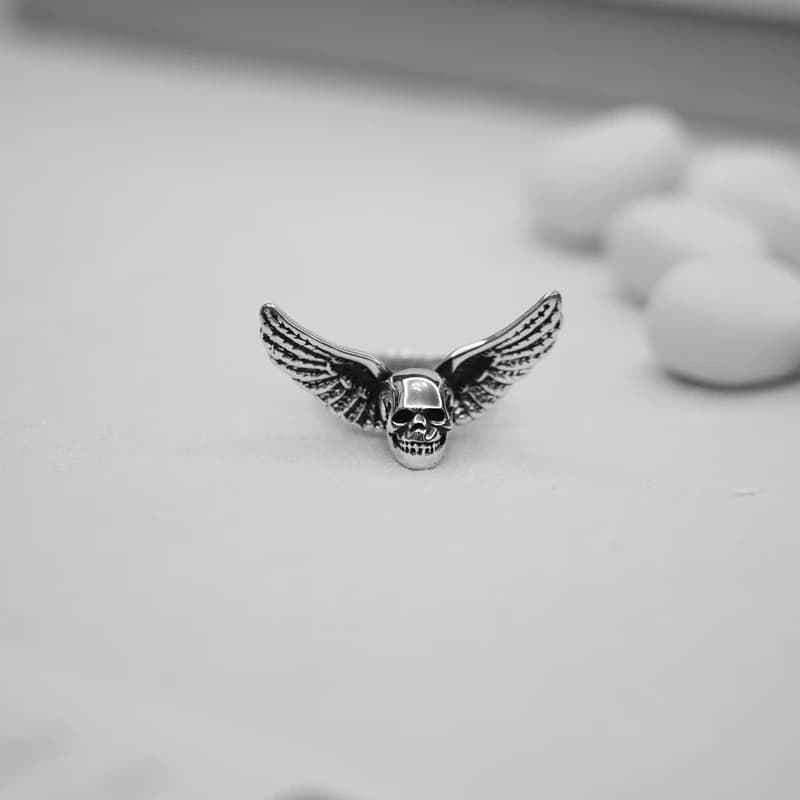 Кольцо с черепом и крыльями на светлой поверхности