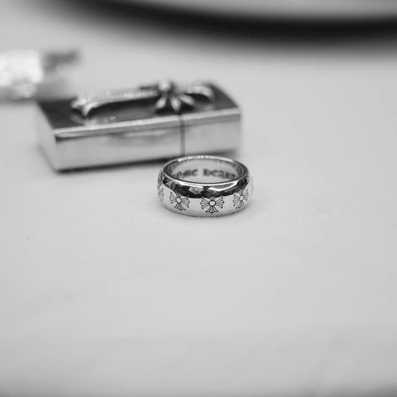 Серебряное кольцо с крестами рядом с фирменной коробкой, композиция