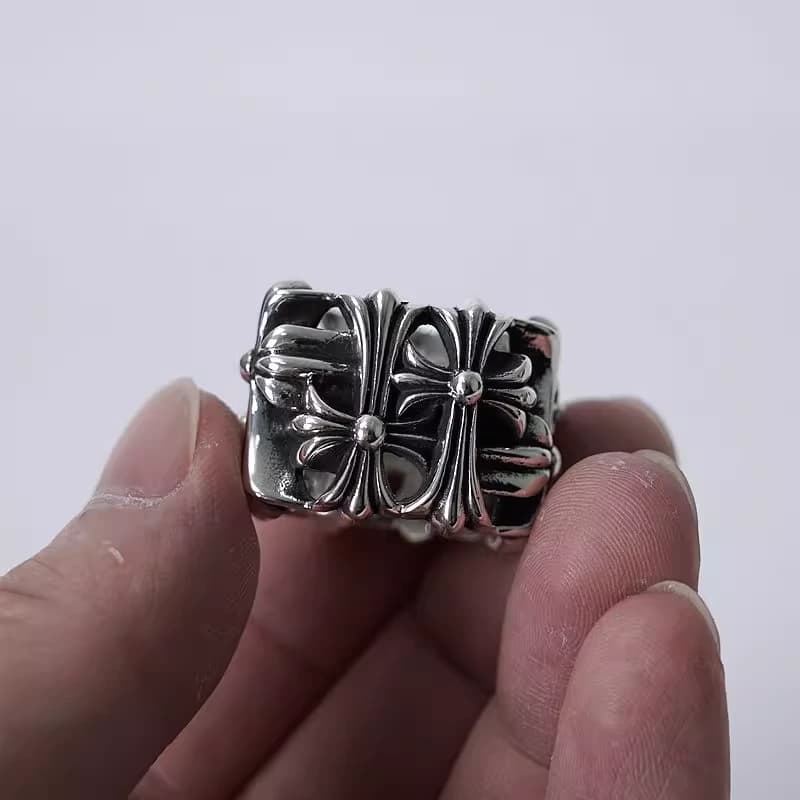 Серебряное фактурное кольцо с крестами в пальцах руки крупным планом