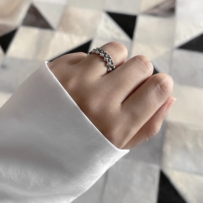 Серебряное рельефное кольцо с зубчатыми краями на пальце, манжет белой рубашки