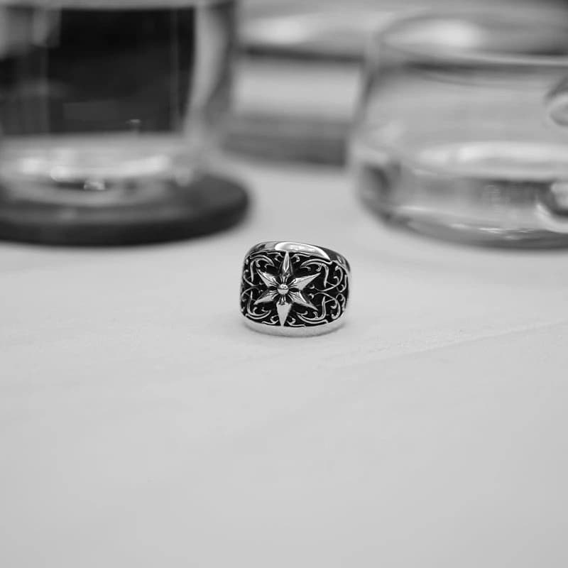 Массивное кольцо со звездой крупным планом на фоне стеклянной посуды