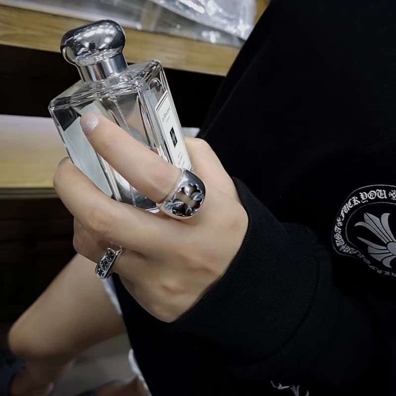 Демонстрация серебряного кольца на руке со стеклянным флаконом