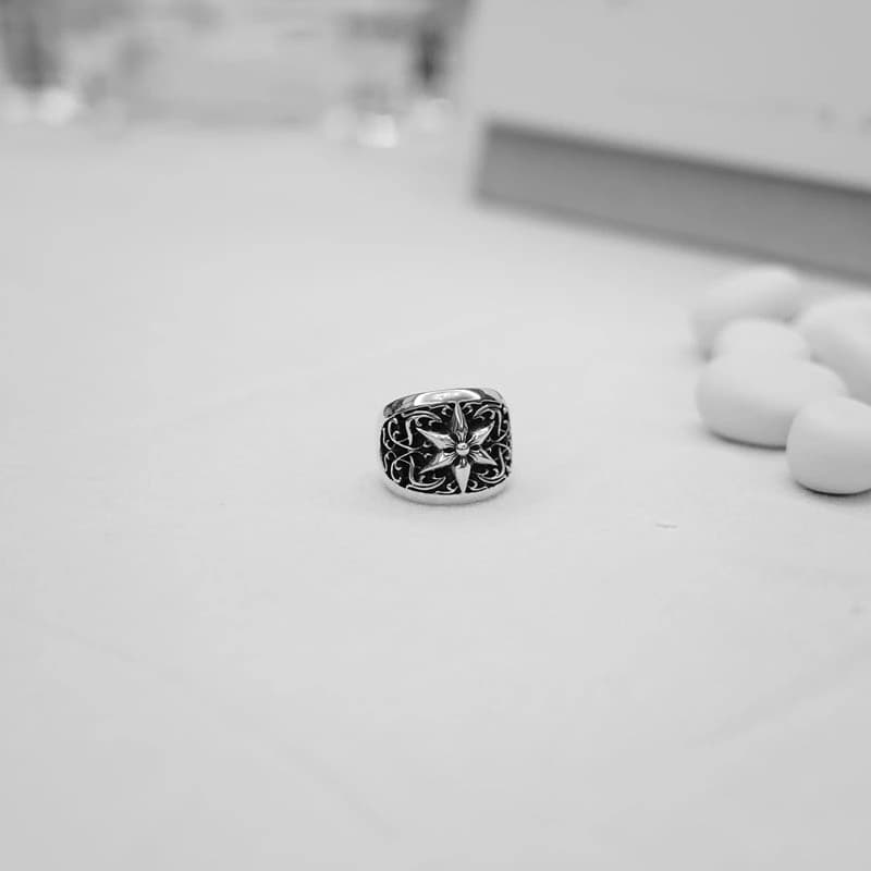 Серебряное кольцо овальной формы на светлой поверхности, общий план