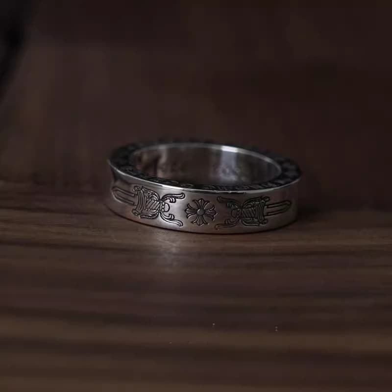 Серебряное кольцо Dagger 6 мм сбоку на деревянном фоне, рельефный кинжал