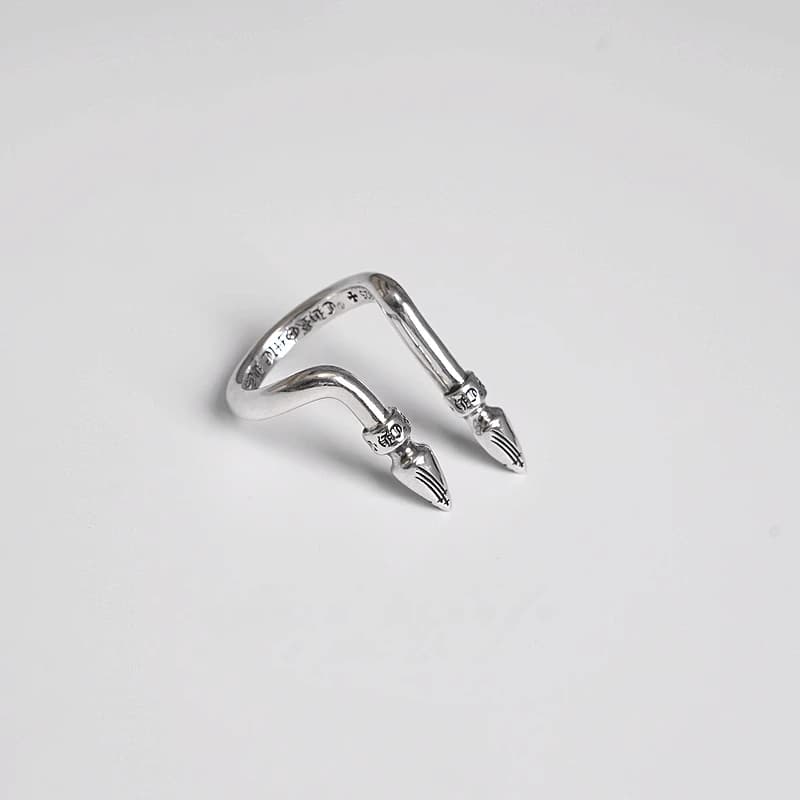 Серебряное кольцо с двумя декоративными шипами на белом фоне