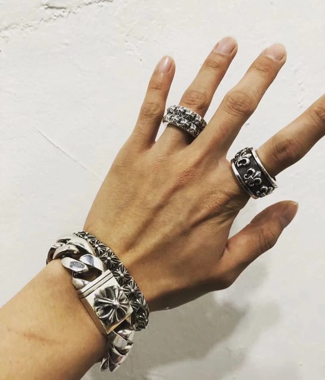 Рука с надетым кольцом BS Fleur Spinner Ring и массивным серебряным браслетом