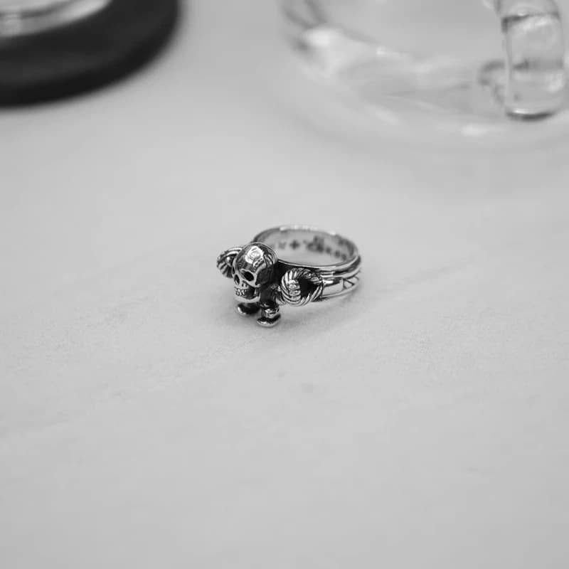 Серебряное кольцо рядом с черным кожаным кошельком с крестами