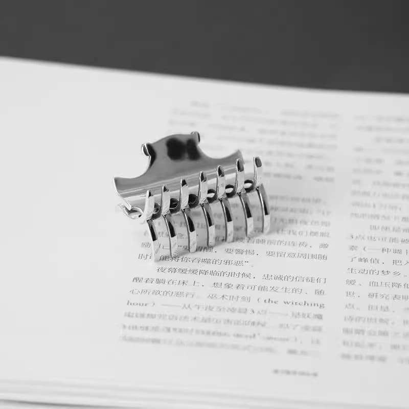 Заколка для волос из серебра на раскрытой книге, вид со стороны зубцов