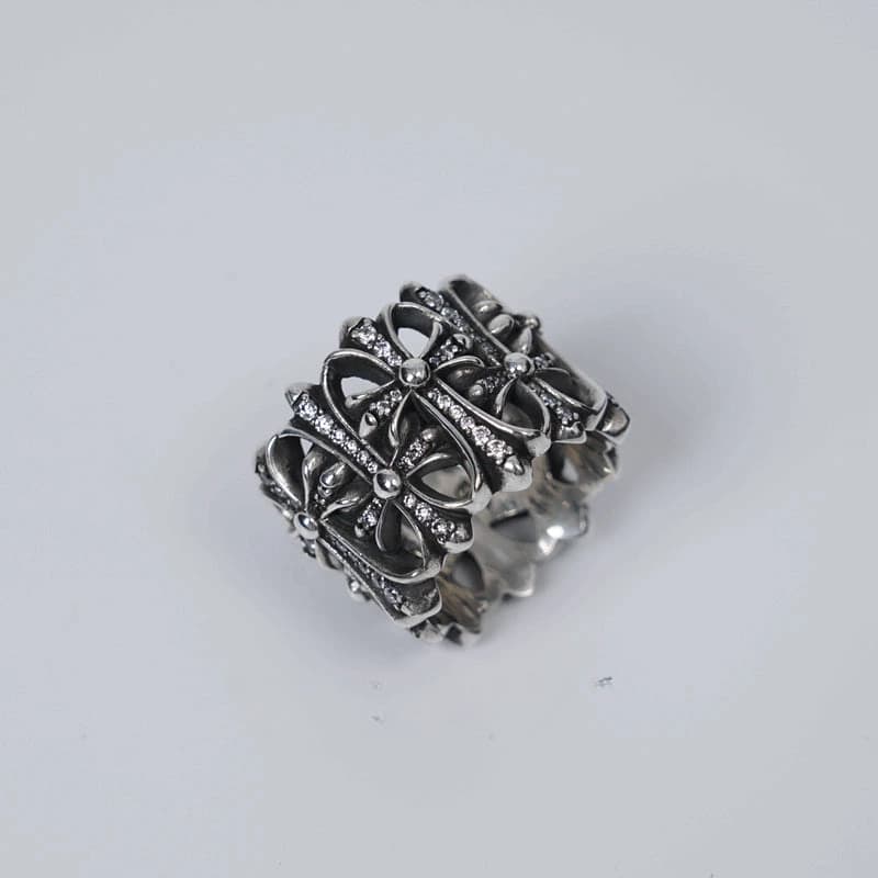 Серебряное кольцо с крестовым узором и камнями на белом фоне