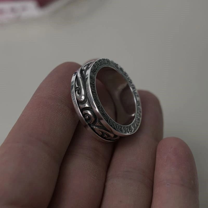 Серебряное кольцо с узором Scroll на пальце руки при боковом освещении