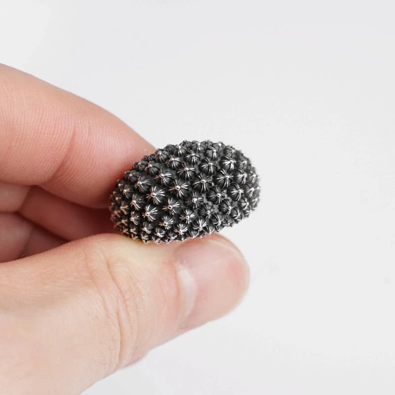 Серебряное кольцо с рельефными крестами в руке крупным планом