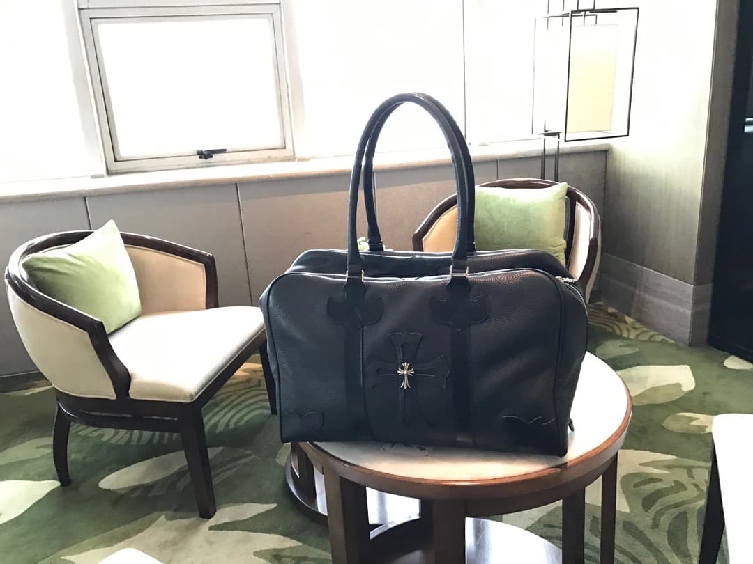 Вид сбоку черной кожаной сумки Chrome Hearts