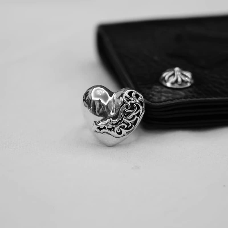 Серебряное кольцо с цветочным орнаментом крупным планом на фоне кошелька
