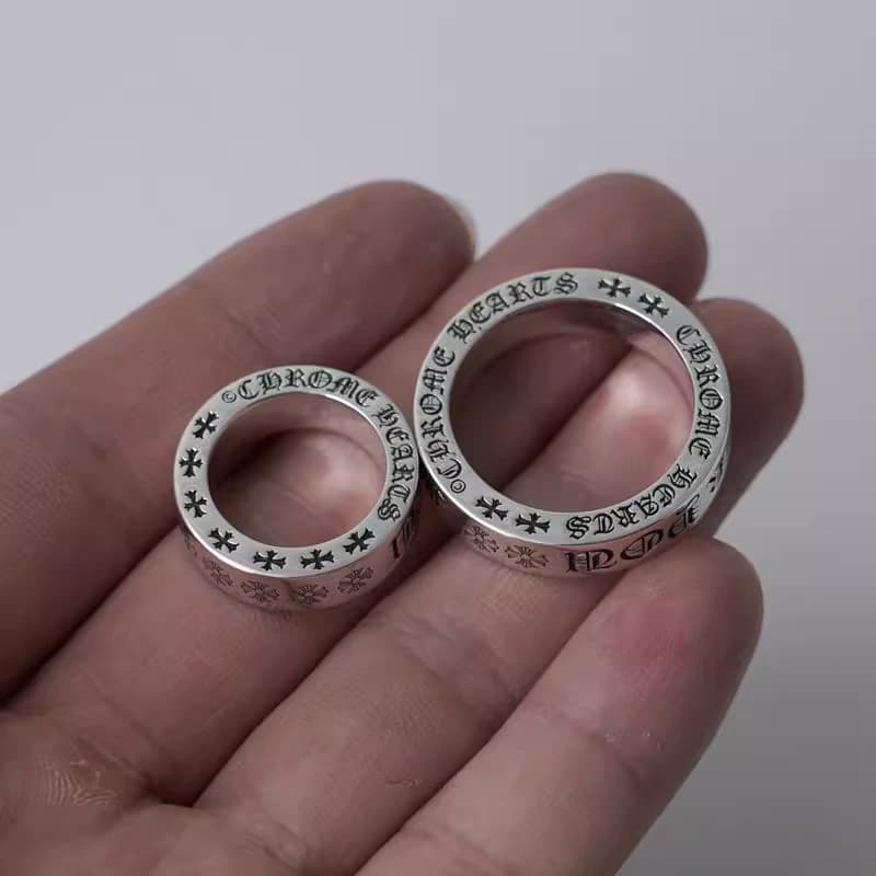 Два серебряных кольца с гравировками разного размера на руке