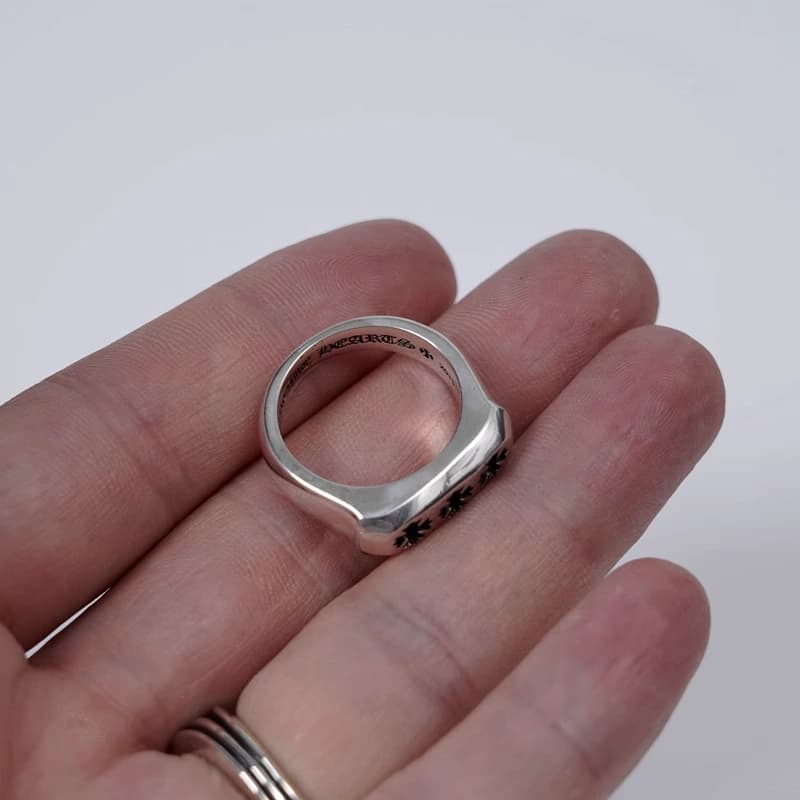 Серебряное кольцо с крестами CH Plus на ладони, вид сверху