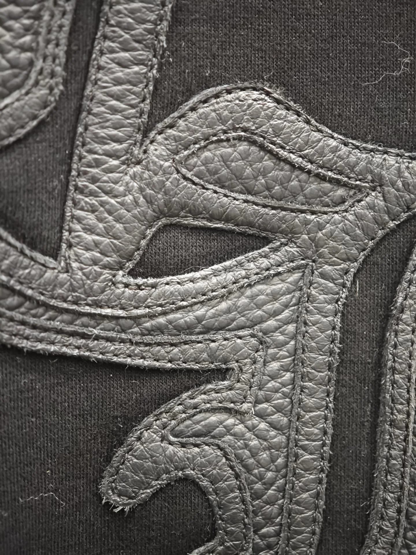 Деталь кожаной аппликации CH на груди куртки Chrome Hearts