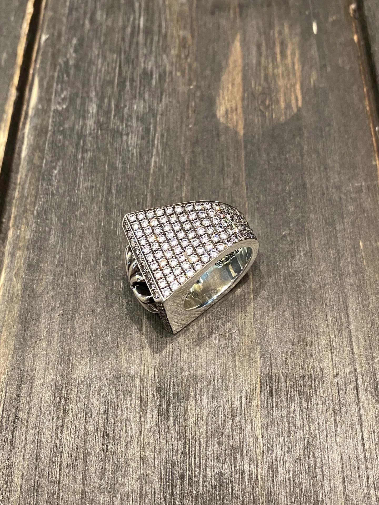 Массивное кольцо Chrome Hearts с инкрустацией камнями, ракурс сбоку на деревянном фоне