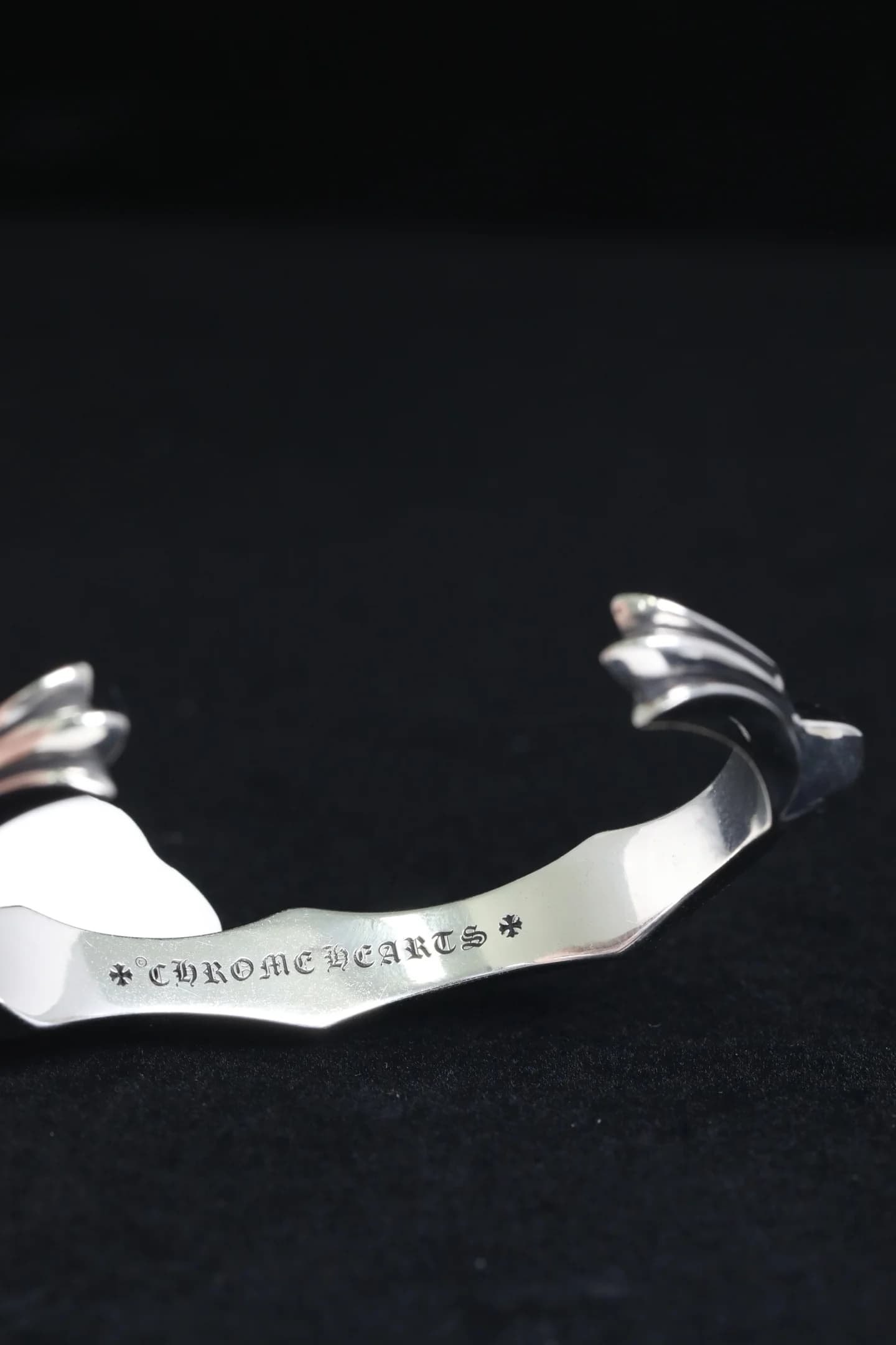 Крупный план фирменной гравировки Chrome Hearts внутри браслета