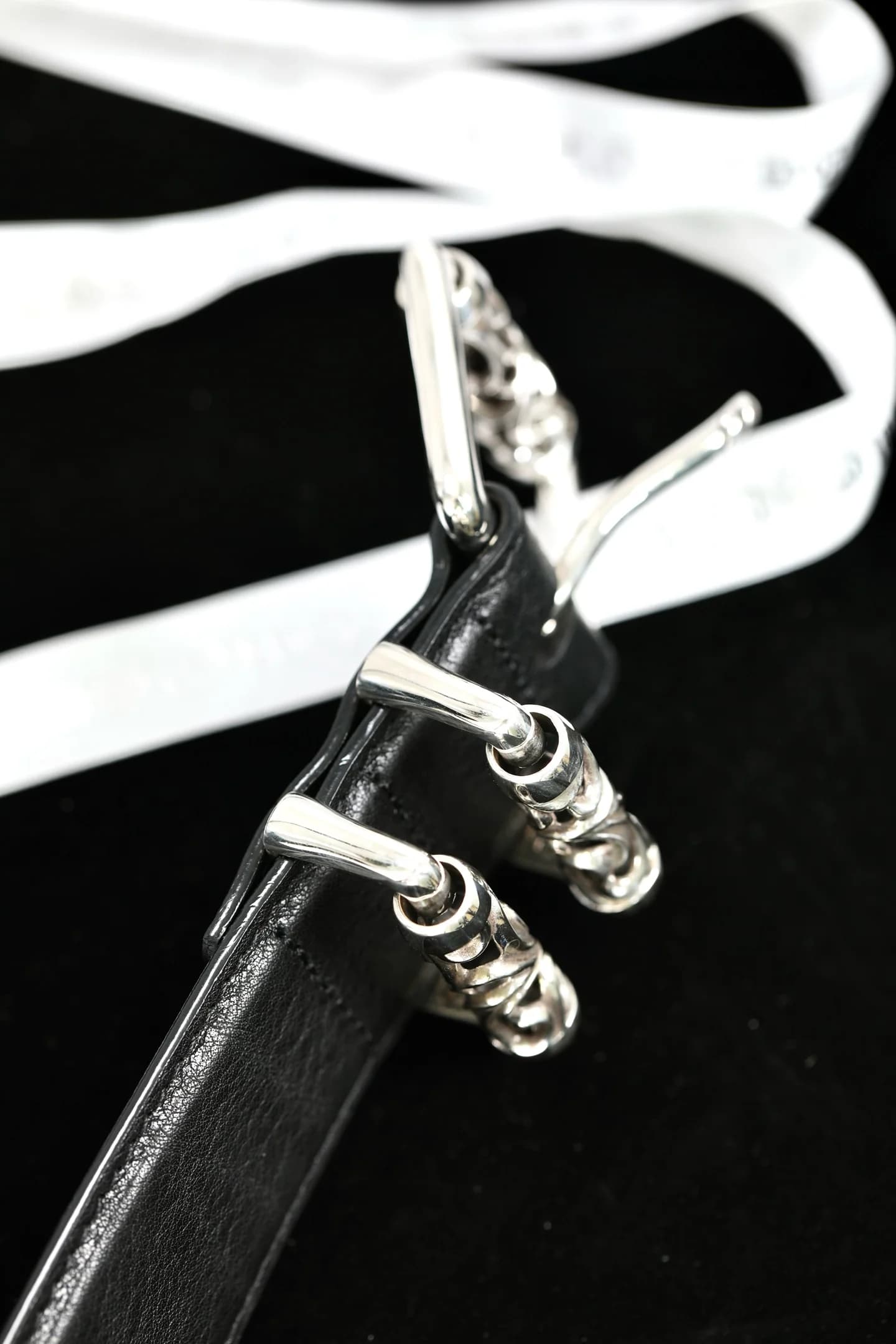 Вид сбоку на серебряные шлёвки и пряжку ремня Chrome Hearts
