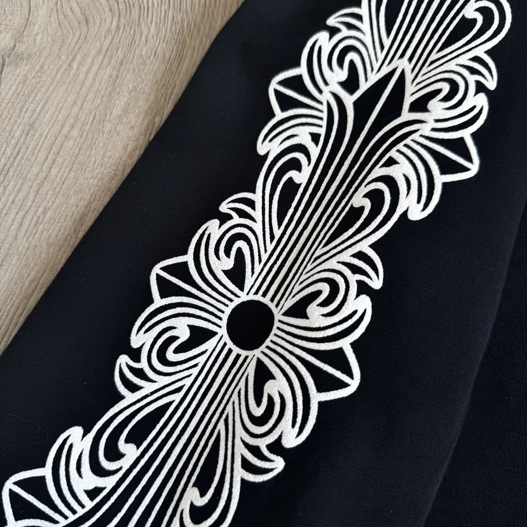 Крупный план белого готического принта на рукаве лонгслива Chrome Hearts