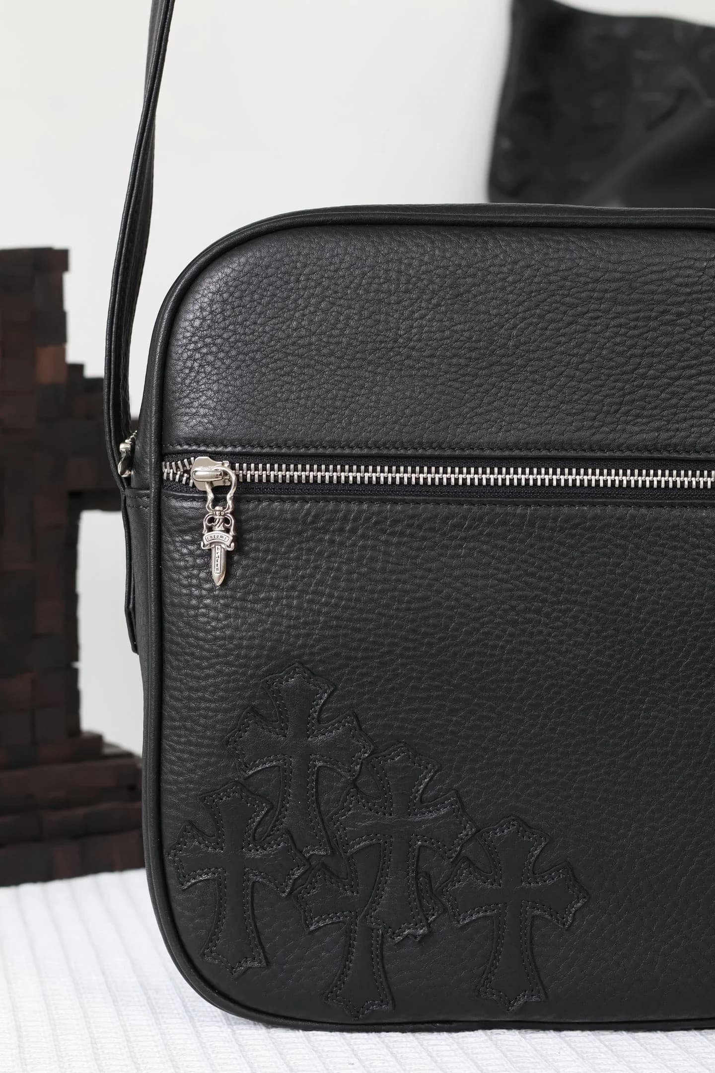 Фронтальная часть черной кожаной сумки Chrome Hearts с фактурной поверхностью