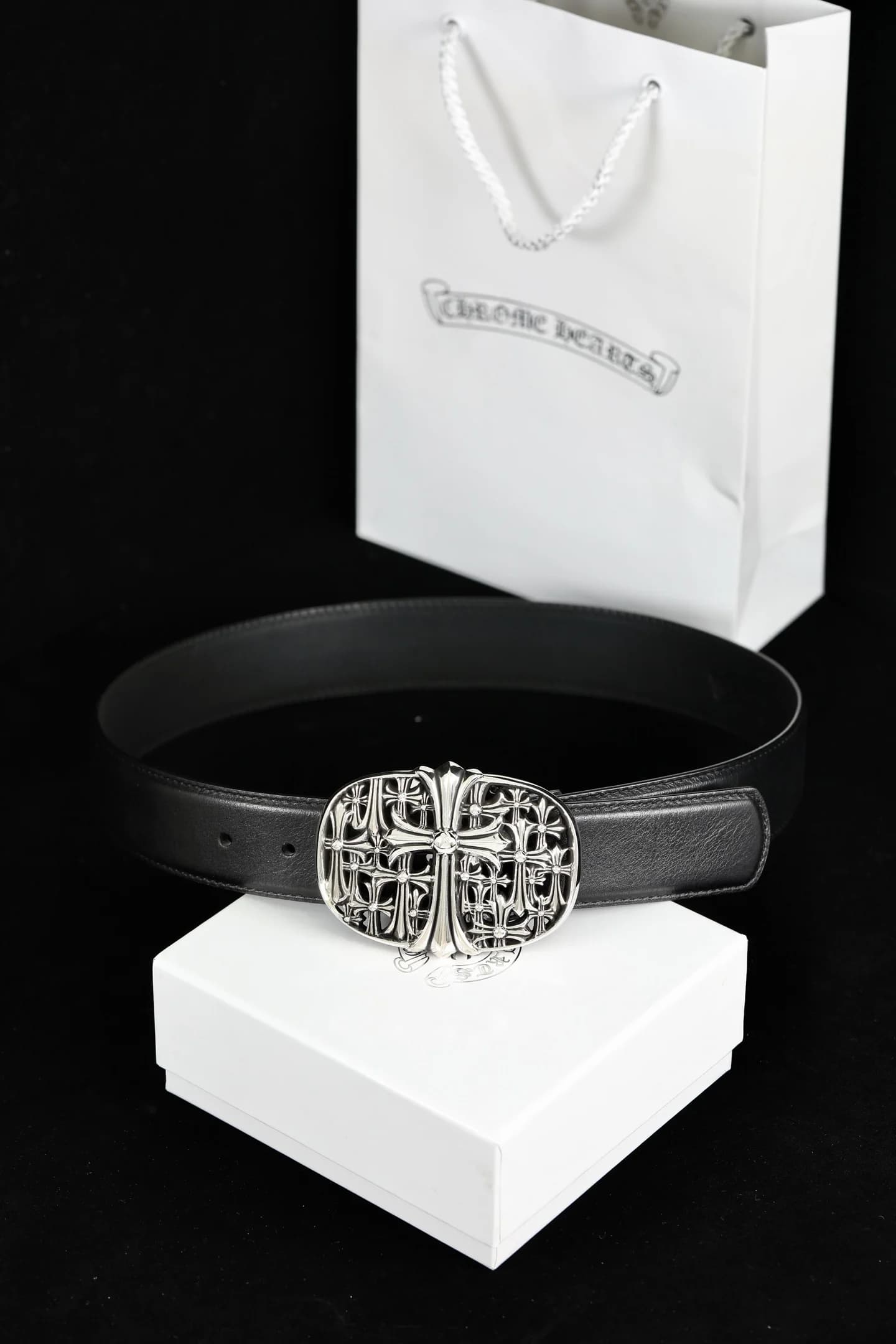 Черный кожаный ремень Chrome Hearts с овальной пряжкой Cemetery на фоне подарочной упаковки